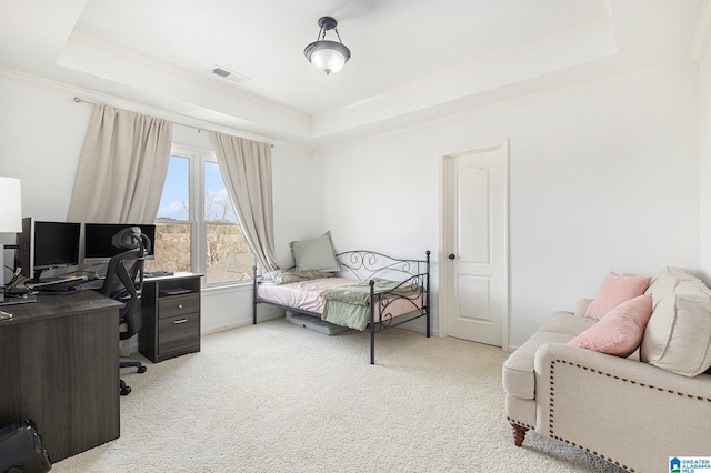 bedroom with ornamental molding, a tray ceiling, and carpet