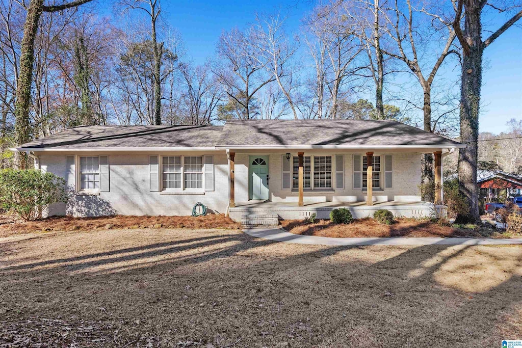 single story home featuring a porch and a front yard