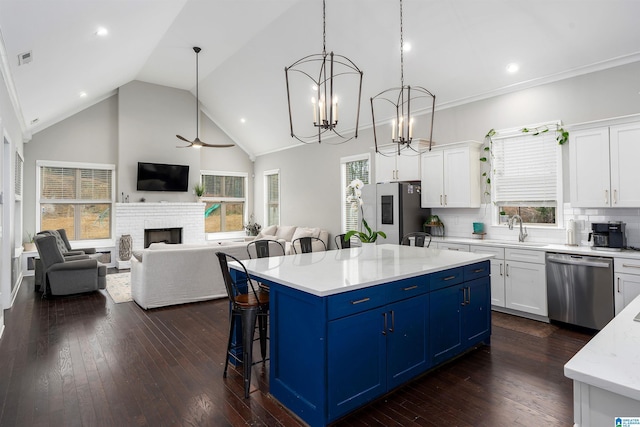 kitchen featuring backsplash, a center island, white cabinets, and appliances with stainless steel finishes