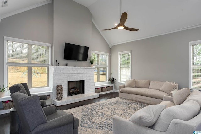 living room with hardwood / wood-style floors, high vaulted ceiling, a brick fireplace, and ceiling fan