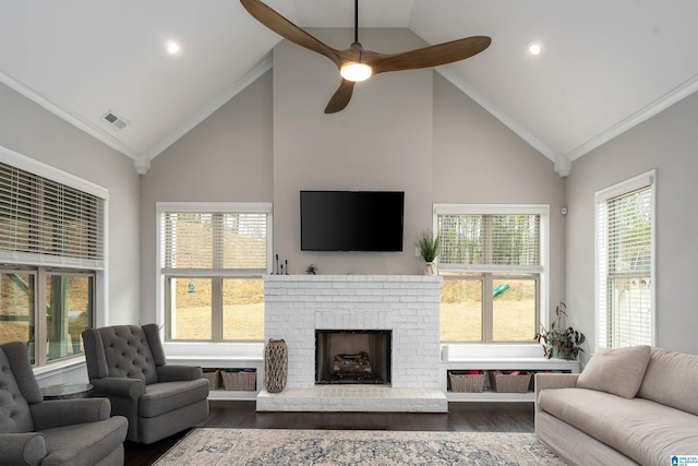 living room with dark wood-type flooring, high vaulted ceiling, ornamental molding, ceiling fan, and a fireplace