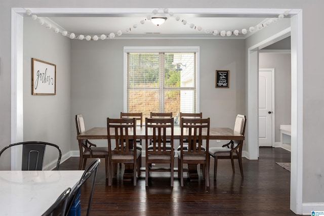 dining room featuring dark wood-type flooring and crown molding