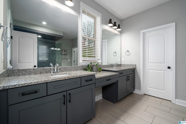 bathroom featuring vanity, a shower with shower door, and a healthy amount of sunlight