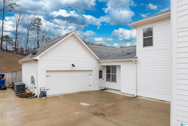 back of property with a garage and central air condition unit