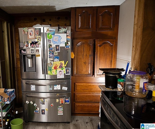 kitchen with stainless steel refrigerator with ice dispenser, electric stove, light hardwood / wood-style floors, and dark brown cabinets