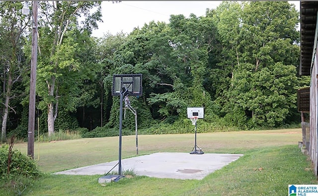 view of basketball court with a yard