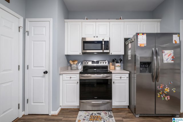 kitchen featuring white cabinetry, appliances with stainless steel finishes, and dark wood-type flooring