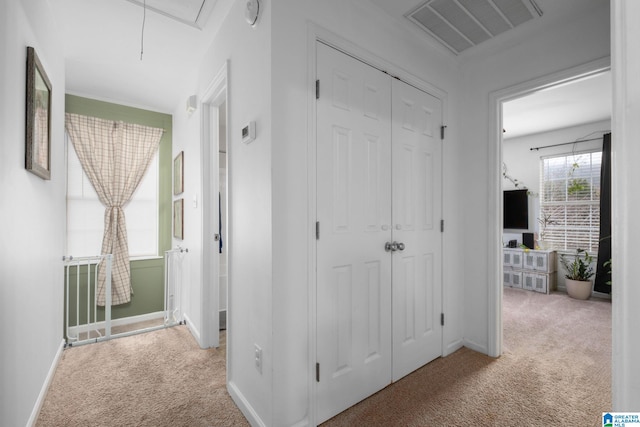 hallway featuring light colored carpet