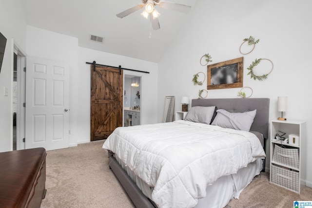 bedroom with ensuite bathroom, high vaulted ceiling, light colored carpet, ceiling fan, and a barn door