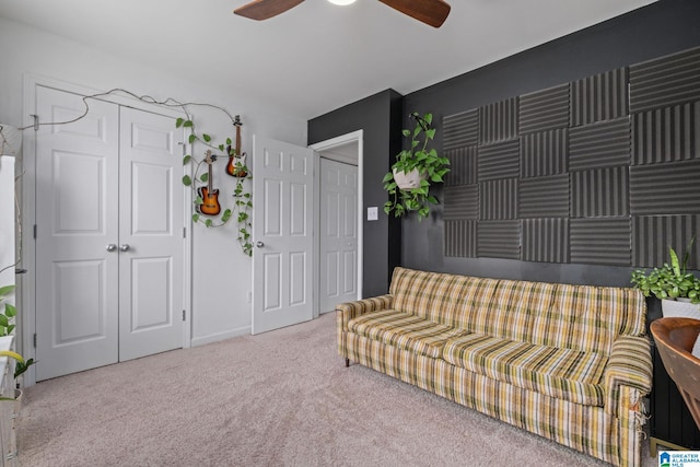 sitting room with ceiling fan and carpet flooring