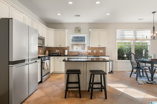 kitchen featuring white cabinetry, an inviting chandelier, decorative light fixtures, stainless steel appliances, and backsplash