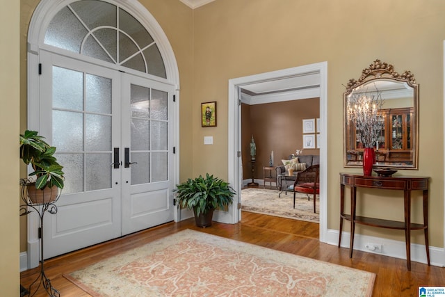 entrance foyer featuring hardwood / wood-style flooring, crown molding, and french doors