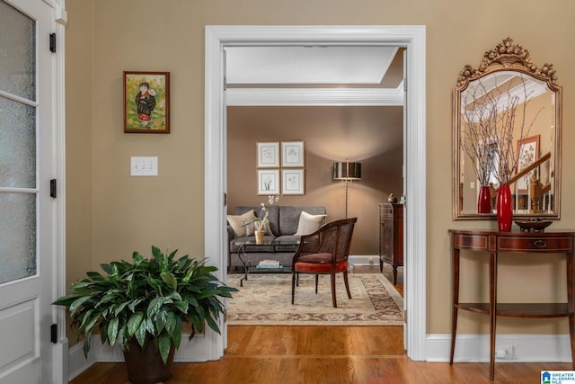 living area with crown molding and hardwood / wood-style floors