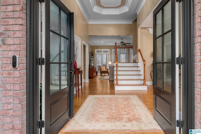 entrance foyer with crown molding, french doors, and light wood-type flooring