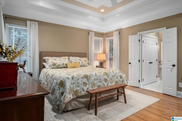 bedroom featuring multiple windows, crown molding, wood-type flooring, and ceiling fan