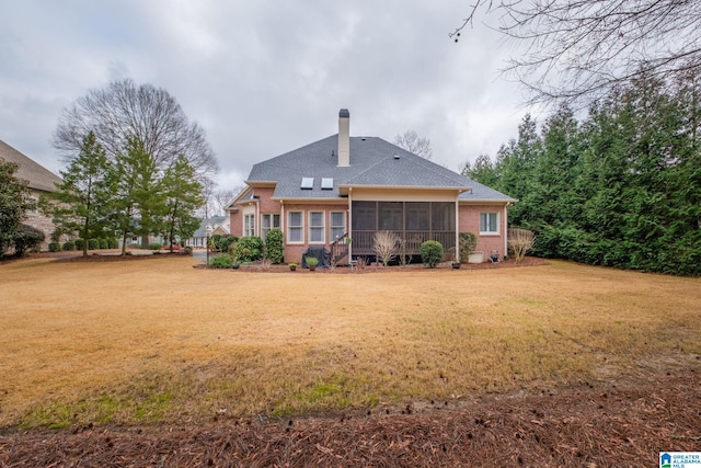 back of house with a sunroom and a yard