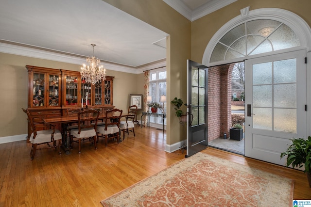 entrance foyer featuring crown molding, hardwood / wood-style floors, and a notable chandelier