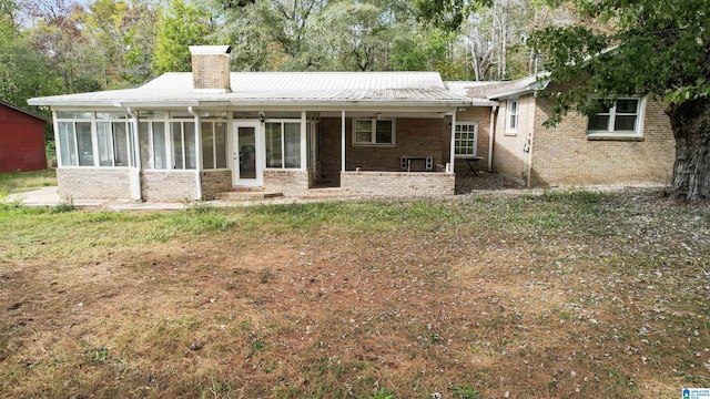 back of house with a sunroom and a yard