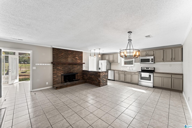 kitchen with pendant lighting, a fireplace, sink, decorative backsplash, and stainless steel appliances