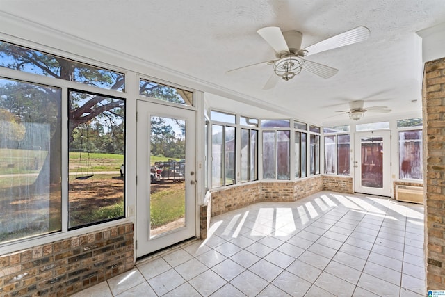 unfurnished sunroom with ceiling fan