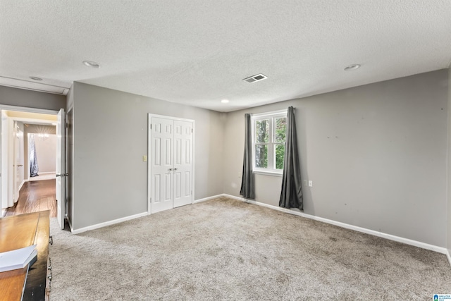 carpeted spare room featuring a textured ceiling