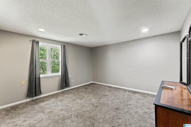 carpeted spare room with a textured ceiling