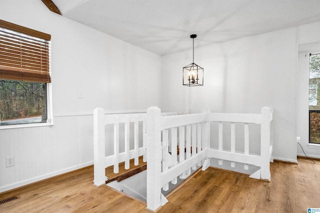 interior space with wood-type flooring, a chandelier, and a wealth of natural light