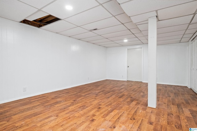 basement featuring wood-type flooring and a drop ceiling