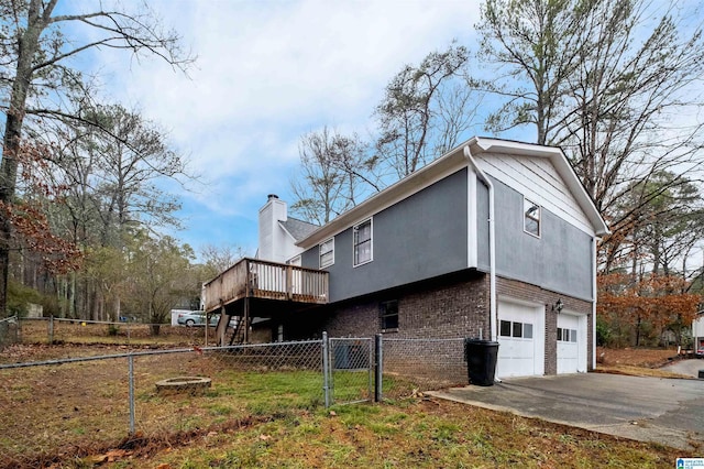 view of side of home with a wooden deck and a garage