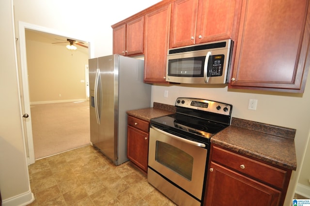 kitchen featuring ceiling fan, stainless steel appliances, and light carpet