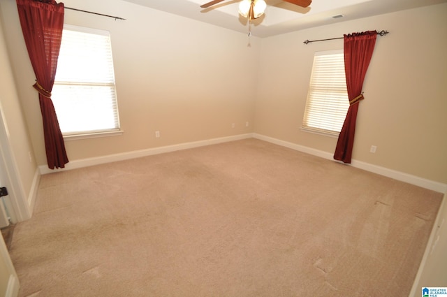 spare room featuring a wealth of natural light, light colored carpet, and ceiling fan