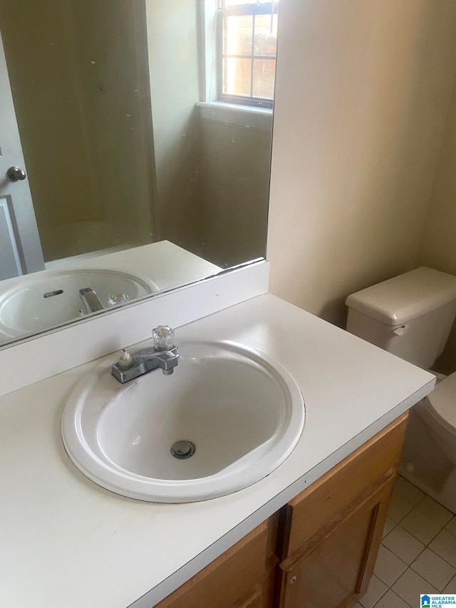 bathroom featuring tile patterned flooring, vanity, and toilet