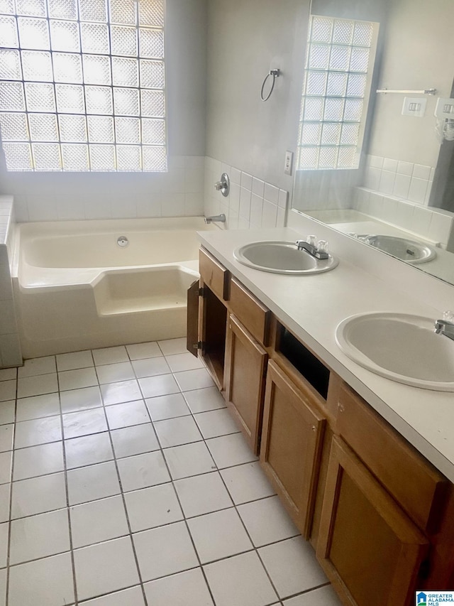 bathroom featuring a tub to relax in, tile patterned floors, vanity, and a wealth of natural light