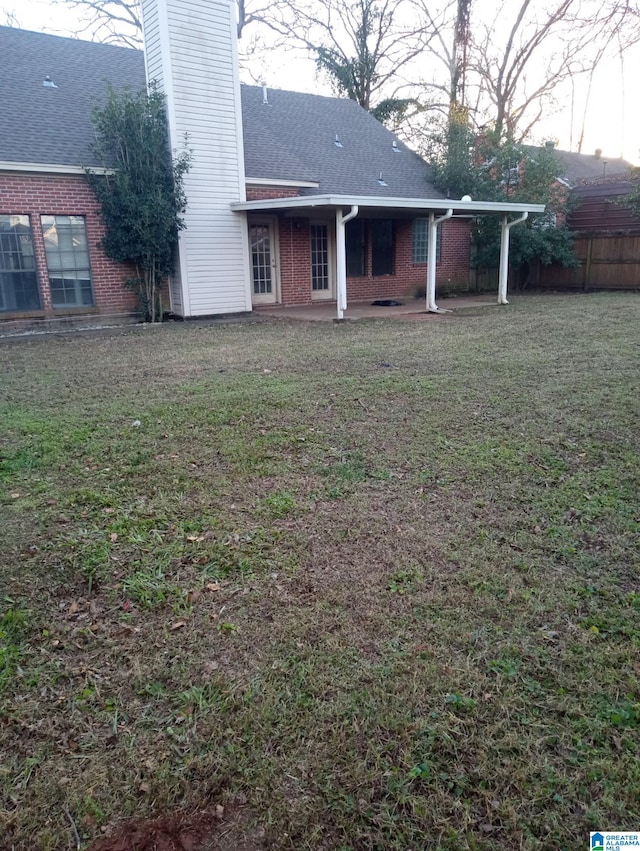 back of house featuring a yard and a patio area