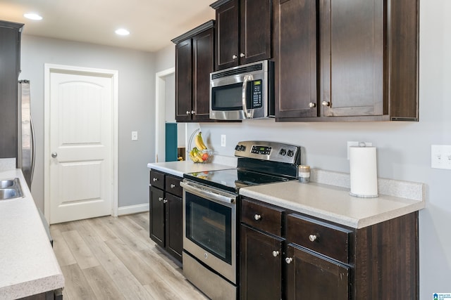 kitchen with dark brown cabinetry, appliances with stainless steel finishes, and light wood-type flooring