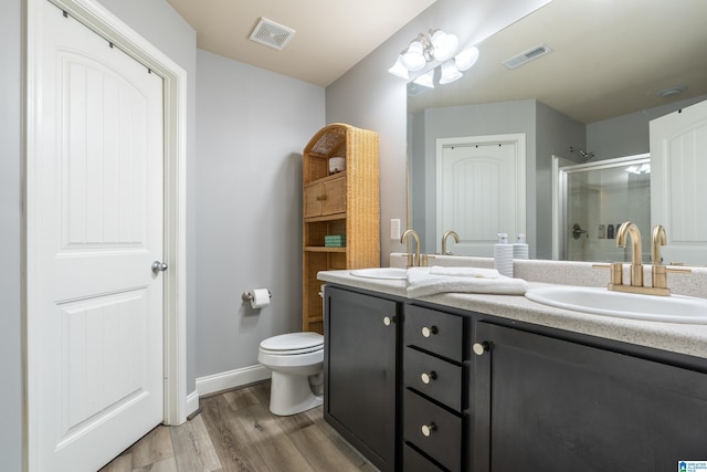 bathroom with vanity, wood-type flooring, a shower with door, and toilet