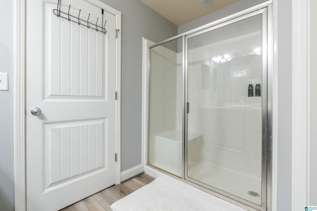 bathroom featuring a shower with door and hardwood / wood-style floors