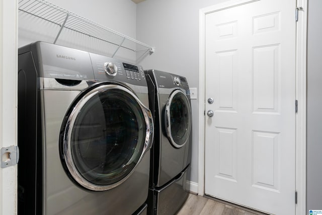 washroom with washer and dryer and light hardwood / wood-style flooring