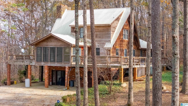 back of property featuring a carport and a sunroom