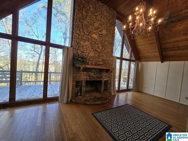 unfurnished living room featuring a healthy amount of sunlight, wood ceiling, and high vaulted ceiling