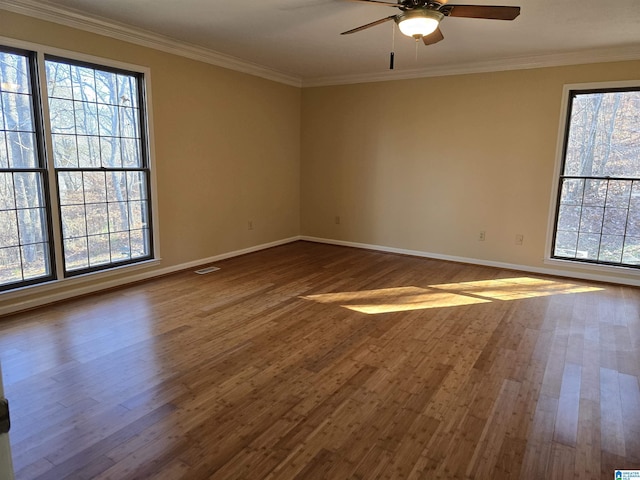 empty room featuring hardwood / wood-style flooring, ornamental molding, and ceiling fan