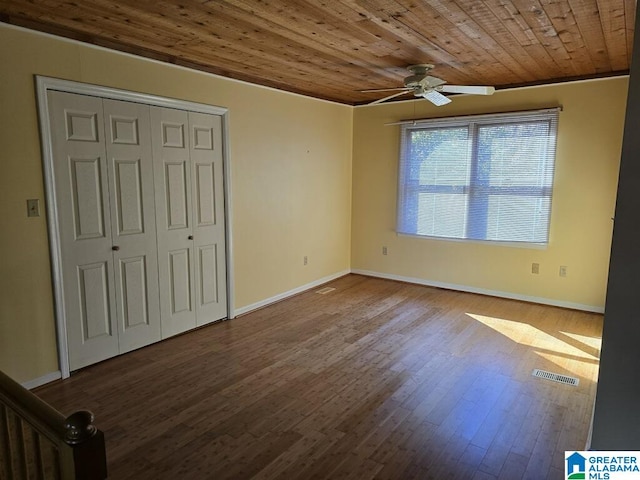 unfurnished bedroom featuring hardwood / wood-style flooring, wooden ceiling, a closet, and ceiling fan