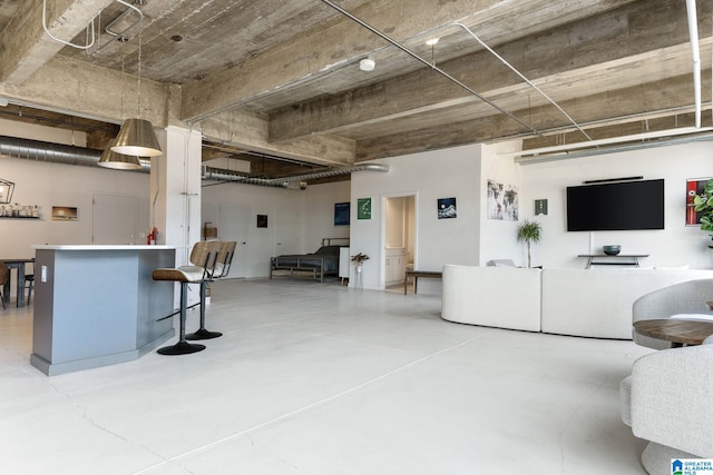 living room with bar and concrete flooring