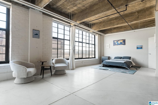 sitting room featuring brick wall and concrete floors