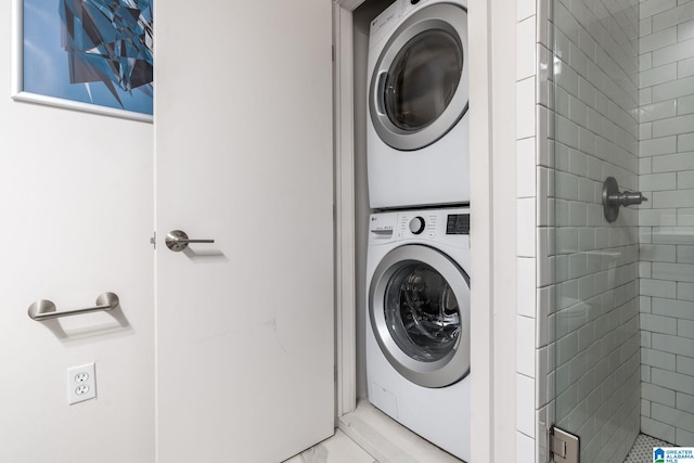 clothes washing area featuring stacked washer and clothes dryer