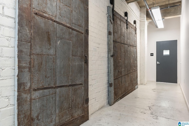 bathroom featuring concrete floors and brick wall