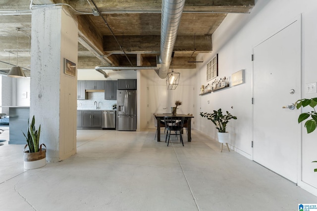 basement featuring sink and stainless steel fridge with ice dispenser