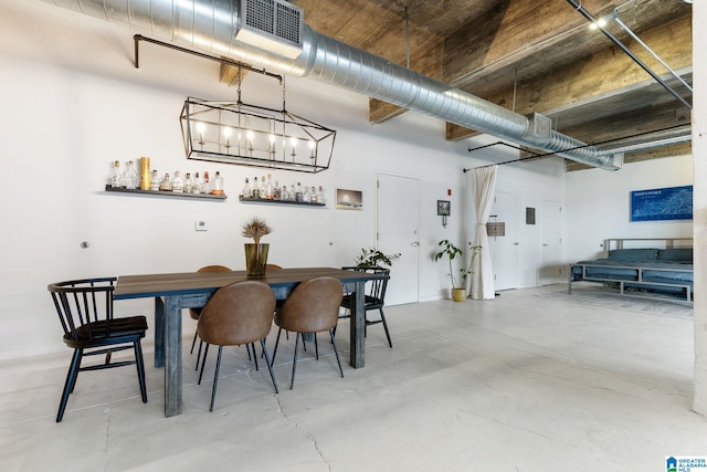 dining space with concrete floors and a high ceiling