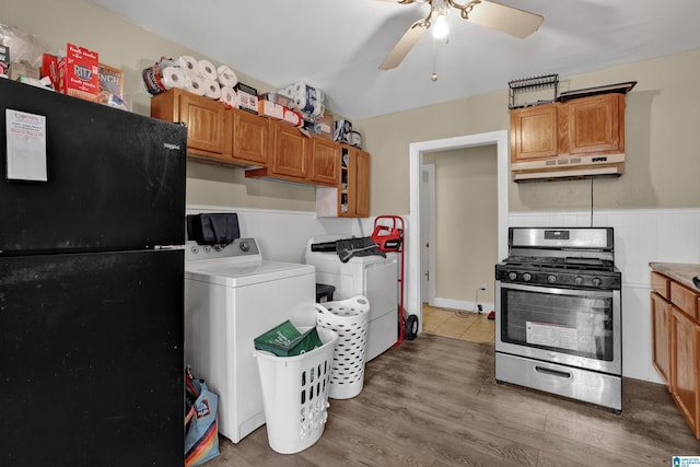 kitchen featuring gas range, black fridge, ceiling fan, independent washer and dryer, and light hardwood / wood-style floors