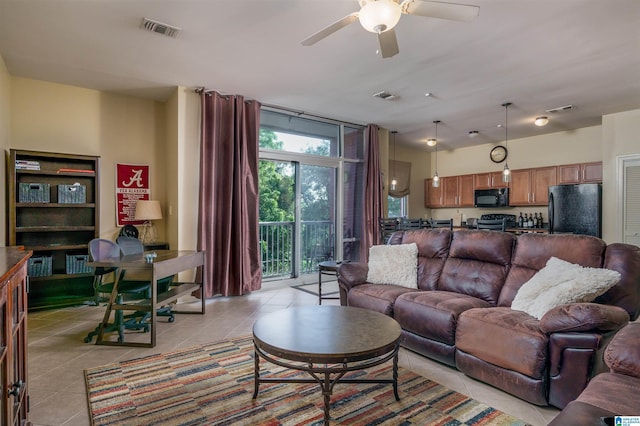 living room with light tile patterned floors, visible vents, and a wall of windows